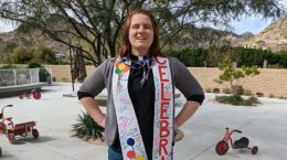 Rev. Sky Williams-Tao standing on patio wearing "CELEBRATE" stole signed by UUCP members