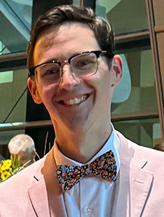 A picture of Daniel Froid wearing a pink suit with a bowtie