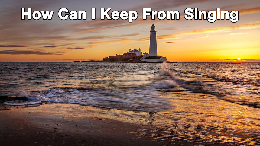 A lighthouse out in the water with a sunset in the background