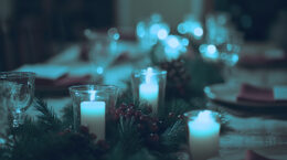 A festive holiday table set with candles and xmas decorations.