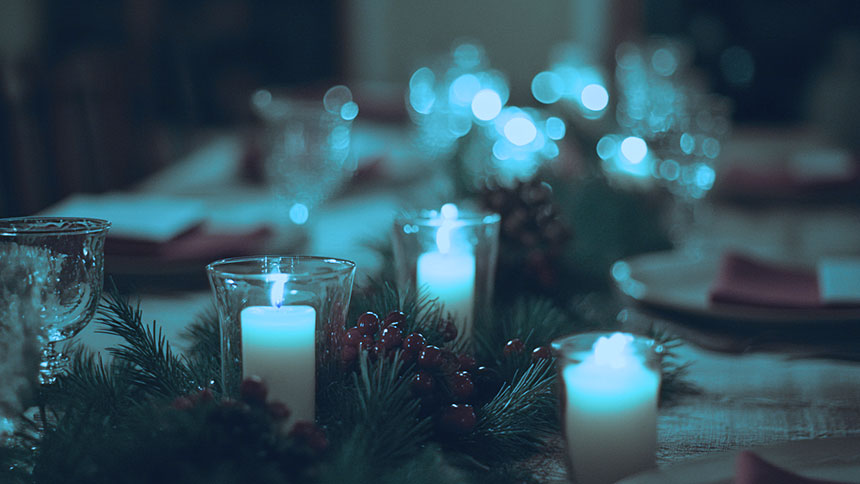 A festive holiday table set with candles and xmas decorations.