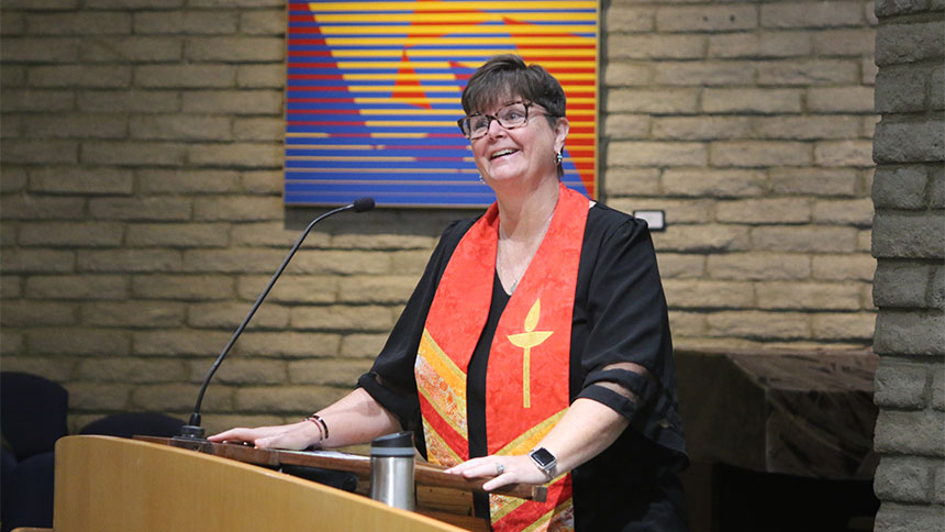 A picture of Reverend Christine at the pulpit during a service.